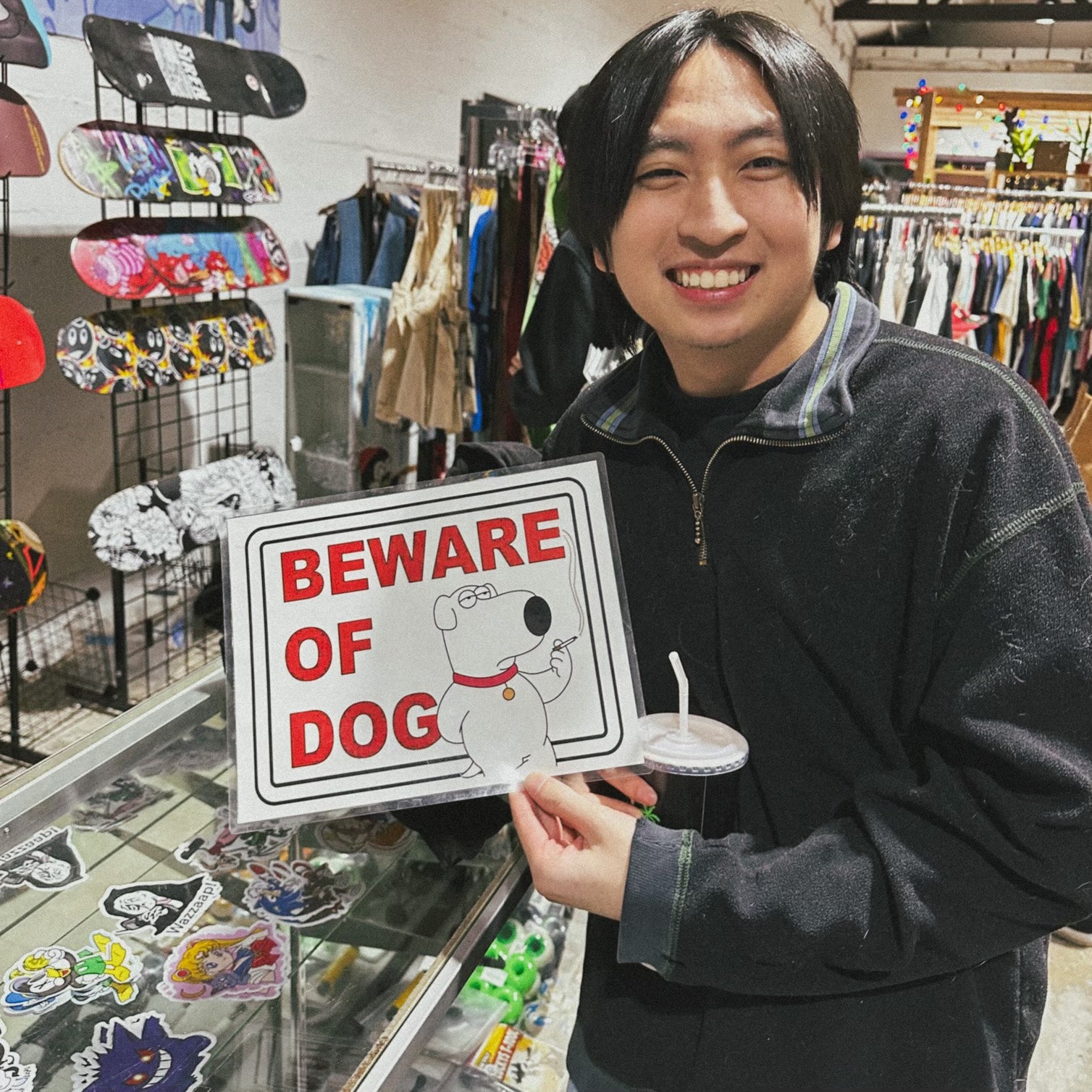 Brin holding a photo of Brian the dog that says "Beware of Dog"